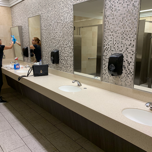 Colby Supreme cleaner wiping mirrors in a commercial bathroom